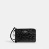 Handgelenktasche mit Reißverschluss an der Ecke aus Signature-Leder mit Herz-Anhänger