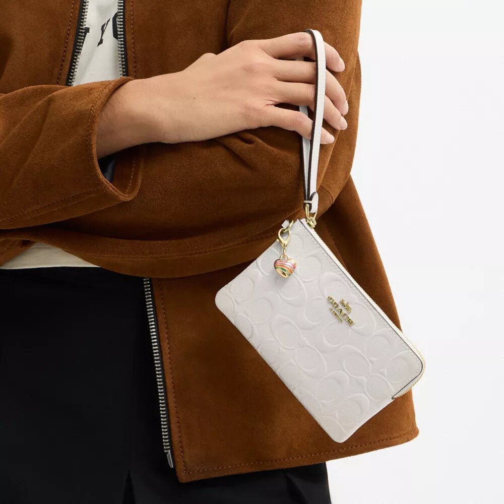 Handgelenktasche mit Reißverschluss an der Ecke aus Signature-Leder mit Herz-Anhänger