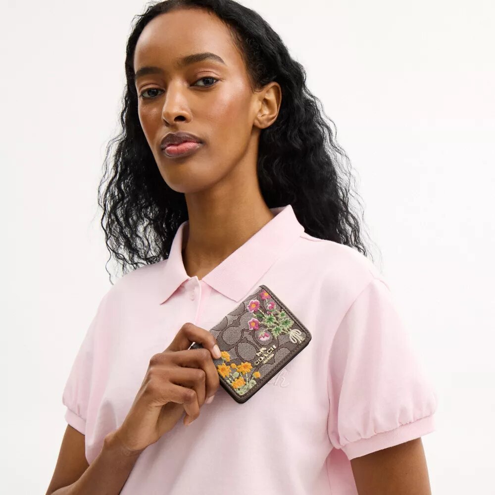 Mini-Geldbörse an einer Kette aus charakteristischem Jacquard mit Blumenstickerei