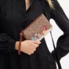 Unverzichtbare kleine Handgelenktasche aus Signature Canvas mit Weihnachtsgeschenken